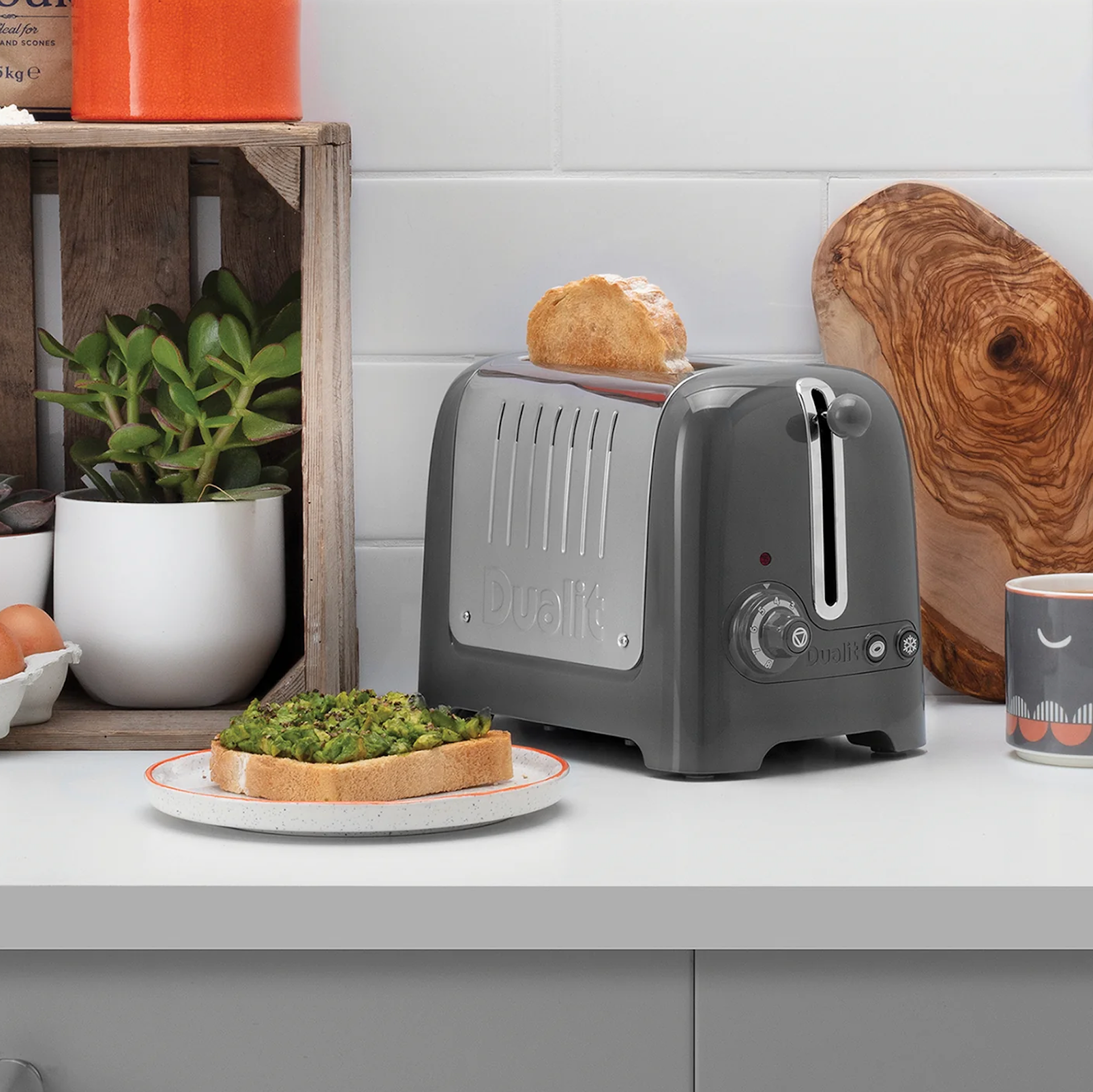 Grey 2-slice toaster on counter with lever and vented front panel