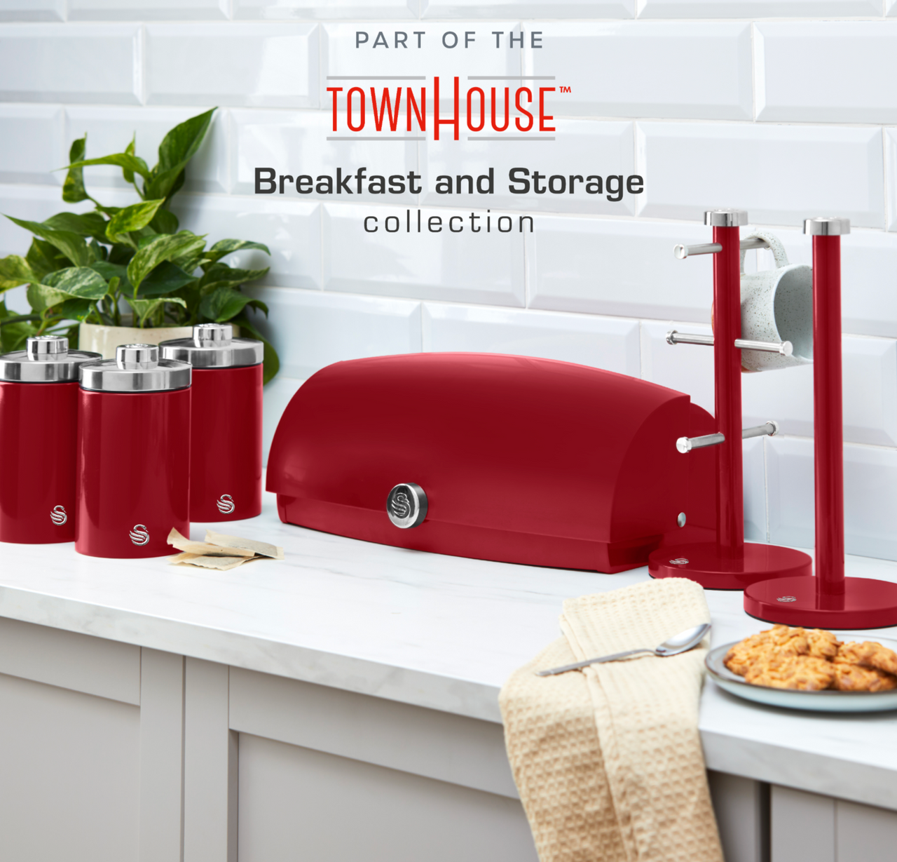 Red kitchen canisters with chrome lids on a white shelf in a breakfast-storage scene.