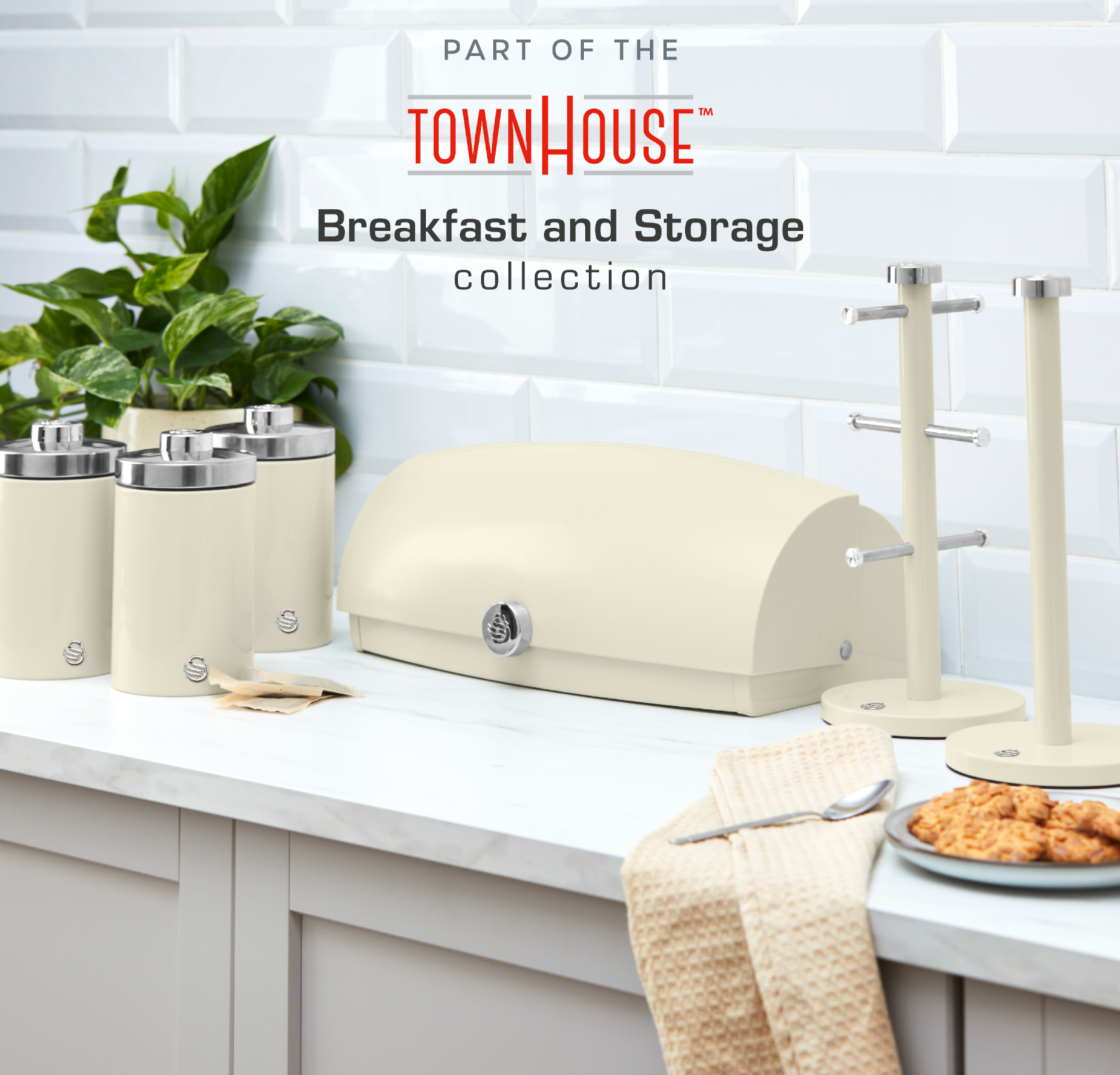 Cream kitchen canisters with chrome lids on white countertop
