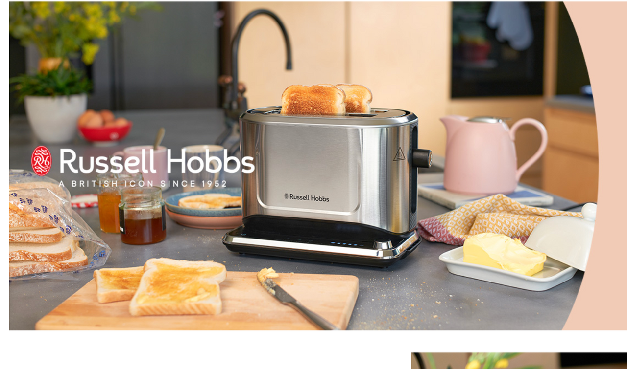 Stainless steel 2-slice toaster with toasting slots and bread, on countertop.