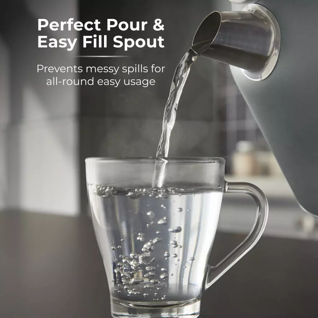 Forest green electric kettle with pour spout filling a glass cup
