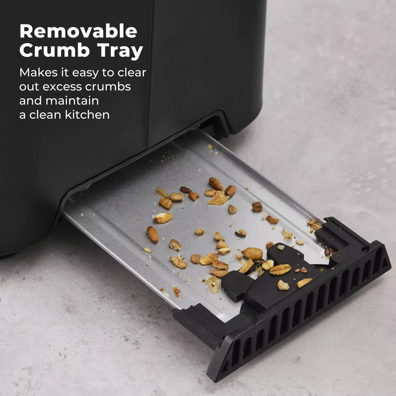 Black toaster with removable crumb tray pulled out, showing crumbs