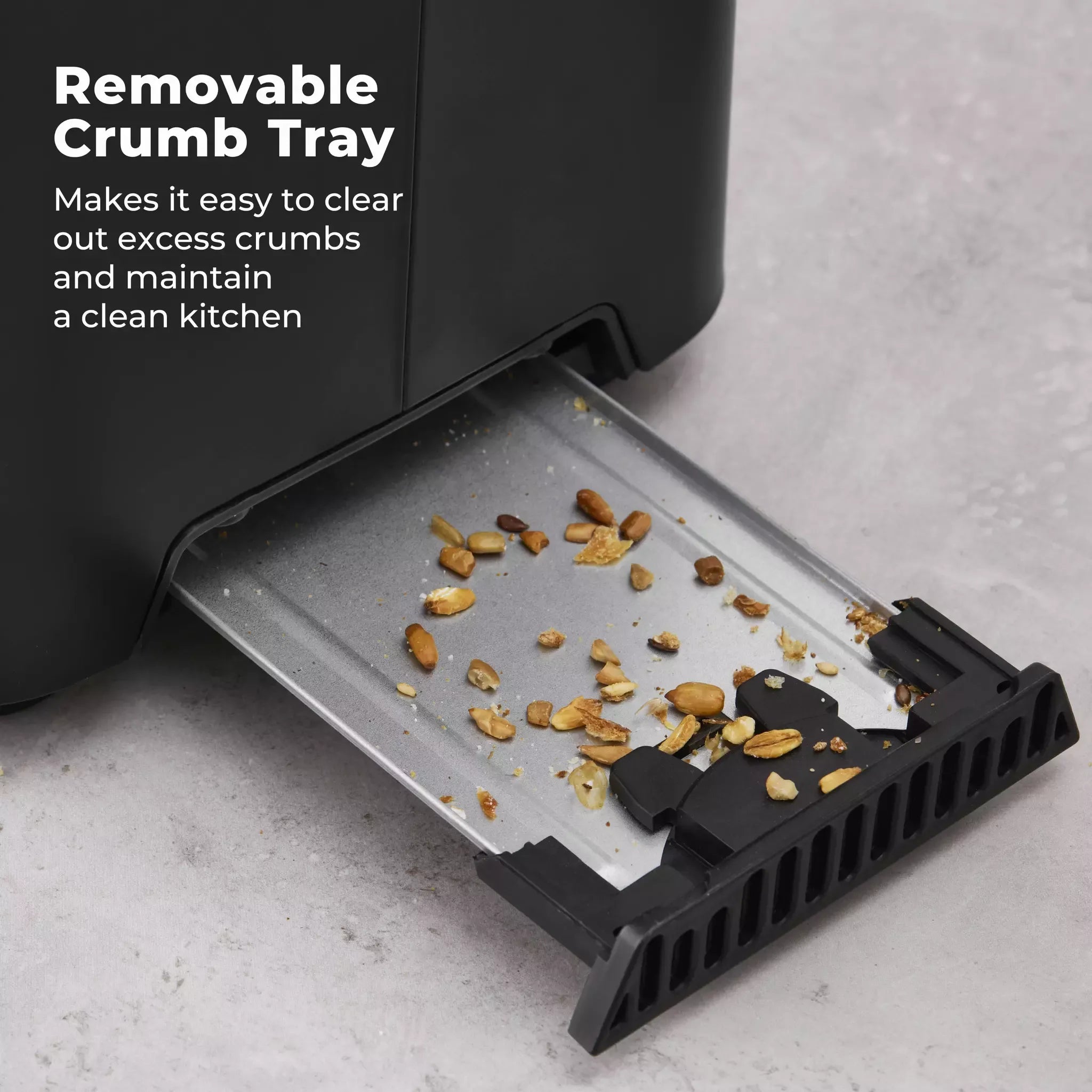 Black toaster with removable crumb tray pulled out, showing crumbs