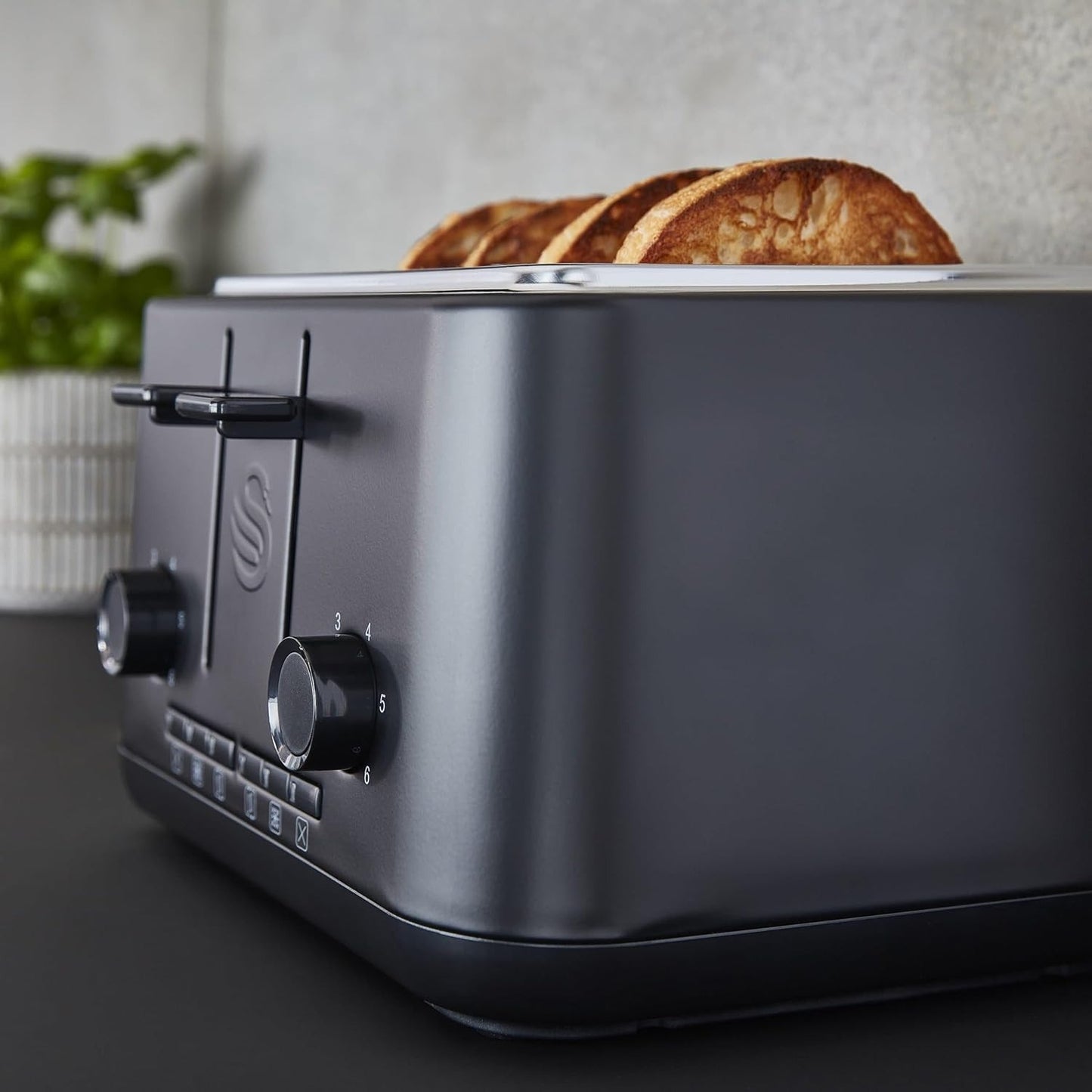 Matt black 4-slice toaster side view with lever and dial