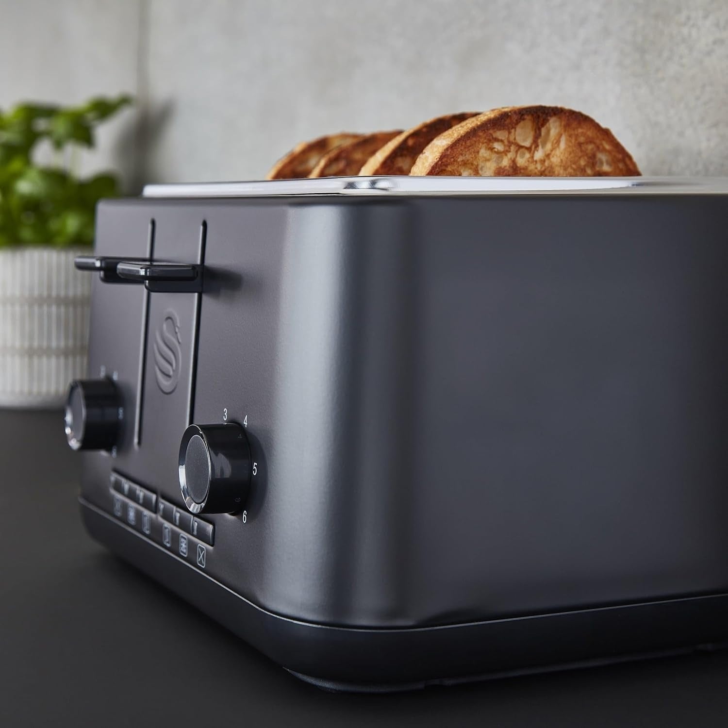 Matt black 4-slice toaster side view with lever and dial