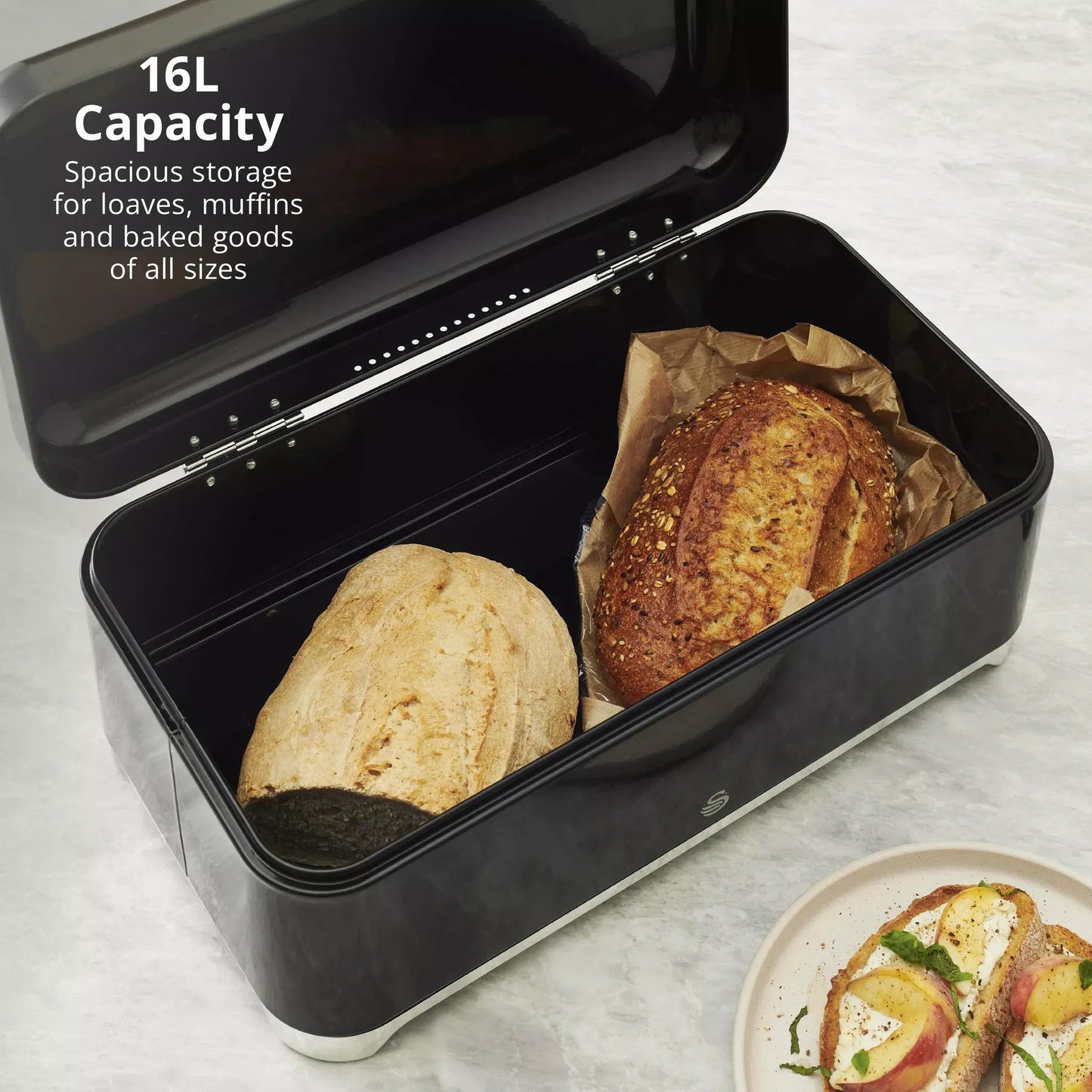 Black bread bin with lid open; two loaf breads stored in the rectangular base