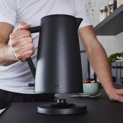 Matt black electric kettle being lifted by the handle