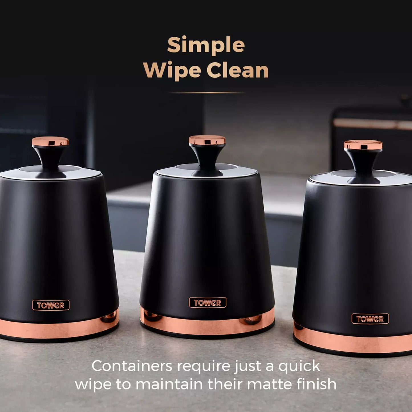 Three black storage canisters with round lids and copper bases