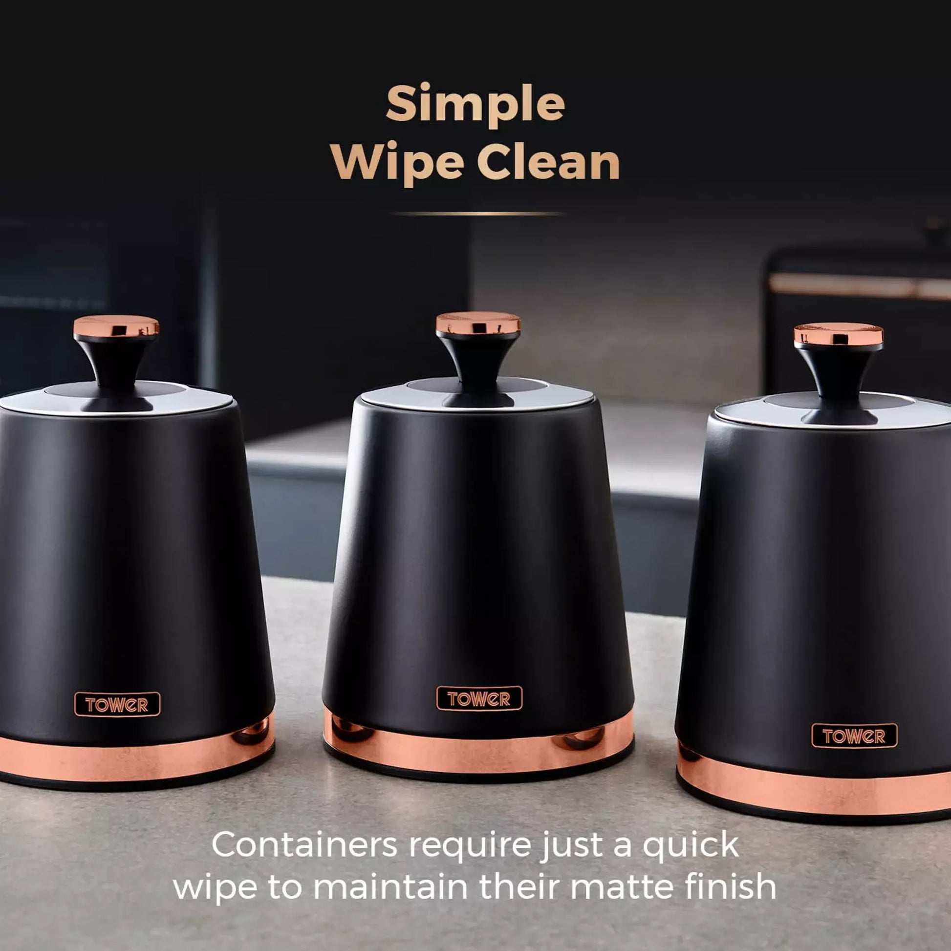 Three black storage canisters with round lids and copper bases