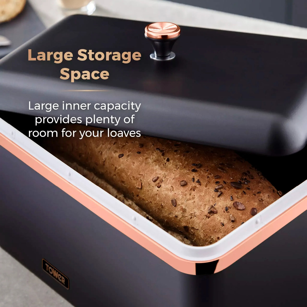 Black bread bin with liftable lid open, loaf inside, rose-gold edge trim