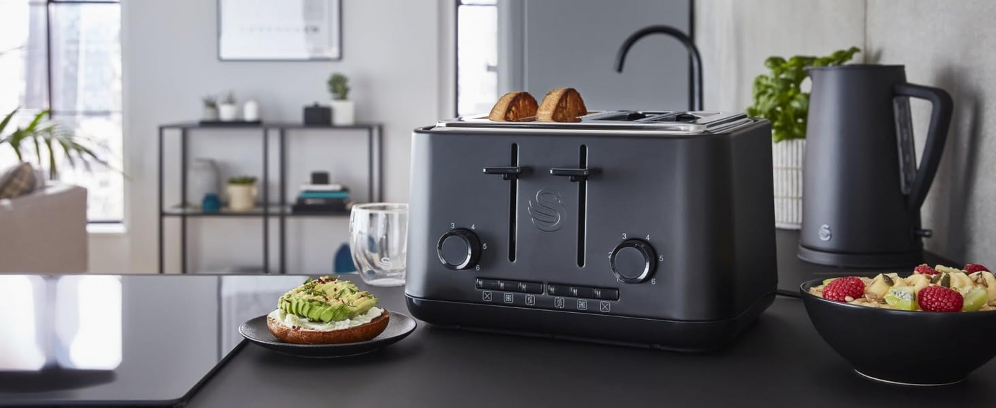 Matt black 4-slice toaster and kettle set on a kitchen counter with bread.