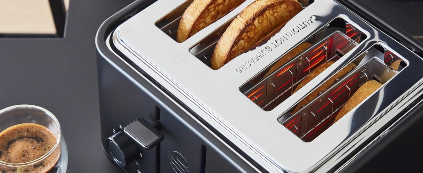 Matt black toaster with bread slices in the chrome slot openings and red glow inside.