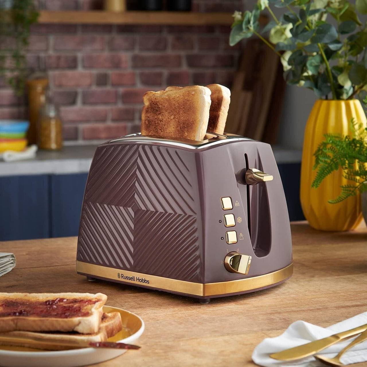Mulberry 2-slice toaster with gold controls; two toast slices raised in the slots.
